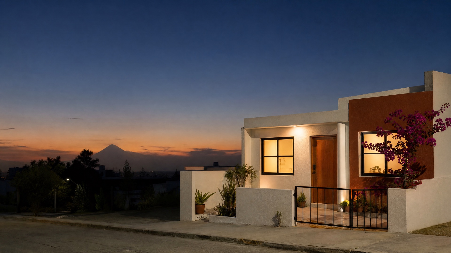 Casa renovada al anochecer en Puebla, con el volcán al fondo